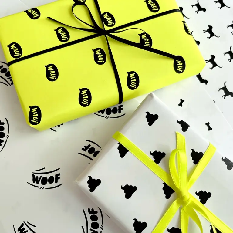 Digitales Hunde-Geschenkpapierset ausgedruckt auf gelbem und weißem Papier, kontrastreiche Hundesymbole, zwei Geschenke darauf – verspieltes Design für Hundeliebhaber