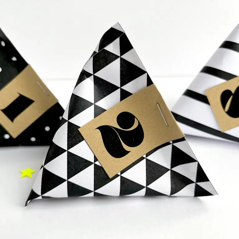 DIY Design-Adventskalender als digitaler Download: Ausdrucke der Pyramiden-Tütchen in Schwarz-Weiß, kombiniert mit Zahlenanhängern aus Kraftpapier als Inspirationsidee – ein persönliches Geschenk für Familie, Freunde oder Partner.